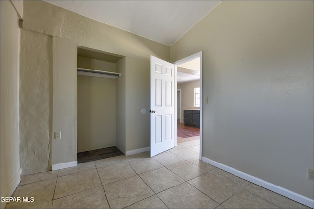 2619 Piedras St Unit A, And B, El Paso, TX 79930 - unfurnished bedroom featuring light tile patterned floors, a closet, lofted ceiling, a textured wall, and baseboards