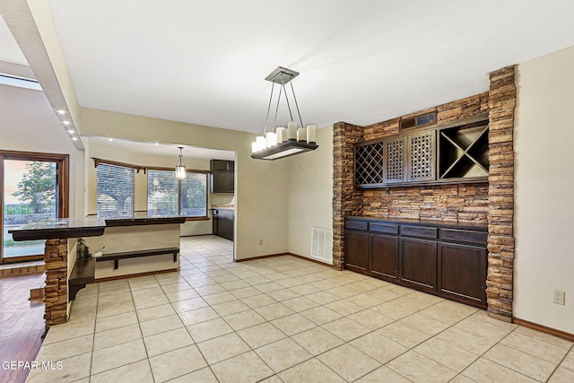 1433 Belvidere St, El Paso, TX 79912 - kitchen featuring dark brown cabinets, dark countertops, baseboards, and decorative light fixtures