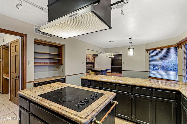 1433 Belvidere St, El Paso, TX 79912 - kitchen featuring black electric stovetop, a center island, light tile patterned flooring, ventilation hood, and dark cabinetry