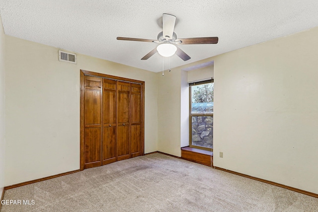 1433 Belvidere St, El Paso, TX 79912 - unfurnished bedroom featuring light carpet, a closet, a textured ceiling, baseboards, and a ceiling fan