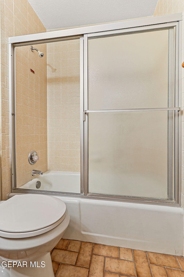 1433 Belvidere St, El Paso, TX 79912 - bathroom featuring toilet and bath / shower combo with glass door