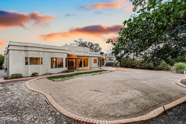 1433 Belvidere St, El Paso, TX 79912 - back of house at dusk with a patio and driveway