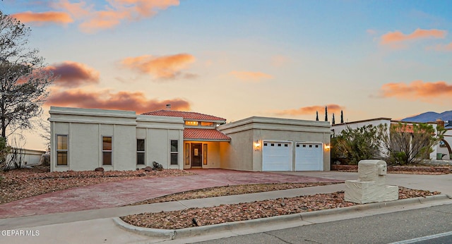 1433 Belvidere St, El Paso, TX 79912 - view of front of house with a tiled roof, concrete driveway, an attached garage, and stucco siding
