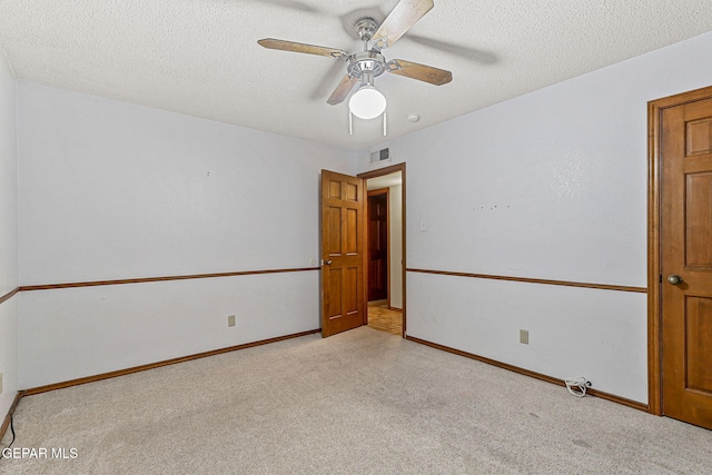1433 Belvidere St, El Paso, TX 79912 - empty room with light carpet, ceiling fan, baseboards, and a textured ceiling