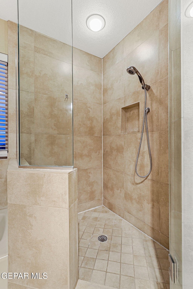 1433 Belvidere St, El Paso, TX 79912 - full bath featuring a tile shower, a textured ceiling, and tile patterned floors