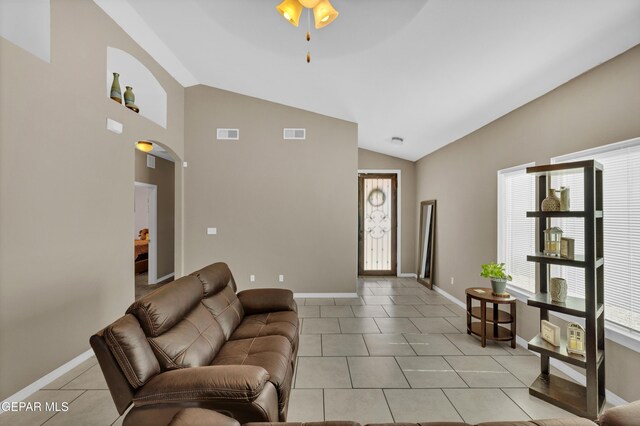 14250 Charles Pollock Ave, El Paso, TX 79938 - living room featuring lofted ceiling, healthy amount of natural light, light tile patterned floors, a ceiling fan, and baseboards