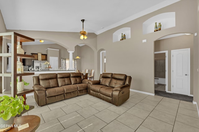 14250 Charles Pollock Ave, El Paso, TX 79938 - living room featuring light tile patterned flooring, arched walkways, ornate columns, baseboards, and a high ceiling