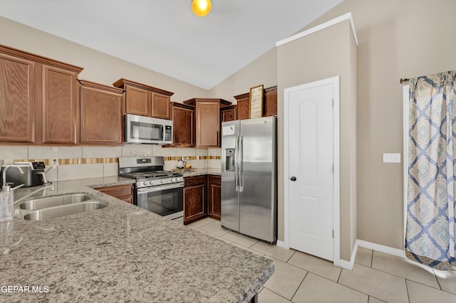 14250 Charles Pollock Ave, El Paso, TX 79938 - kitchen with stainless steel appliances, vaulted ceiling, a sink, light stone counters, and light tile patterned floors