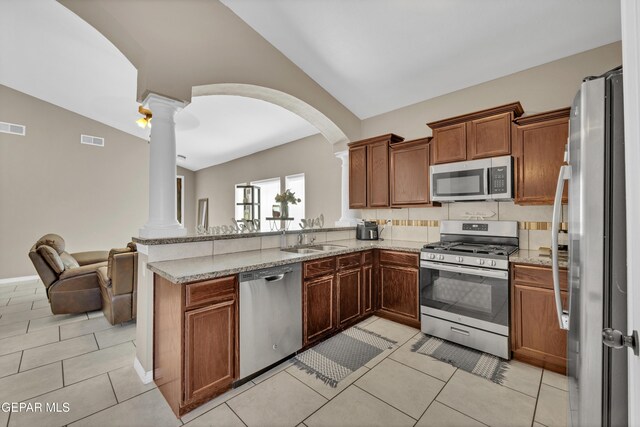 14250 Charles Pollock Ave, El Paso, TX 79938 - kitchen featuring stainless steel appliances, ornate columns, a peninsula, arched walkways, and open floor plan