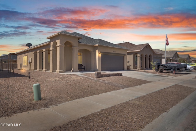 14250 Charles Pollock Ave, El Paso, TX 79938 - view of front facade with stucco siding, an attached garage, and driveway