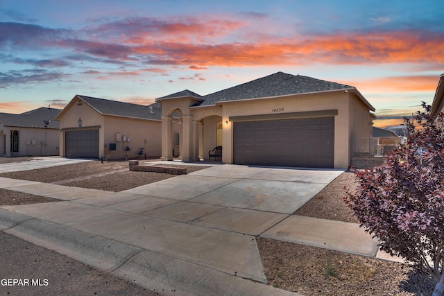 14250 Charles Pollock Ave, El Paso, TX 79938 - view of front of home featuring an attached garage, driveway, stucco siding, and roof with shingles