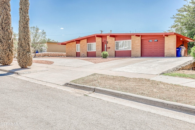 3223 Suffolk Rd, El Paso, TX 79925 - view of front of home with concrete driveway, brick siding, and an attached garage