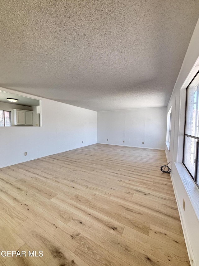 5808 Dearborne Dr, El Paso, TX 79924 - empty room with light wood-style floors, a textured ceiling, and plenty of natural light