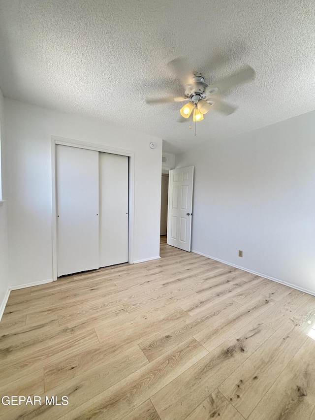 5808 Dearborne Dr, El Paso, TX 79924 - unfurnished bedroom featuring light wood-style flooring, a closet, a textured ceiling, and a ceiling fan