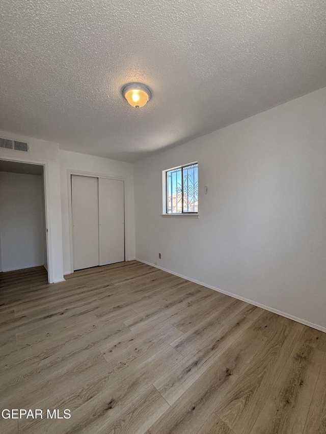 5808 Dearborne Dr, El Paso, TX 79924 - unfurnished bedroom with a textured ceiling, wood finished floors, and a closet