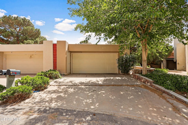 5744 Mira Grande Dr, El Paso, TX 79912 - pueblo revival-style home featuring an attached garage, stucco siding, and concrete driveway