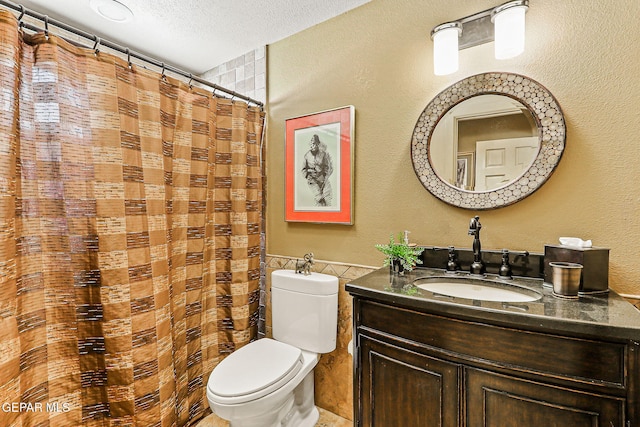 5744 Mira Grande Dr, El Paso, TX 79912 - bathroom with tile walls, toilet, vanity, a textured ceiling, and a shower with shower curtain