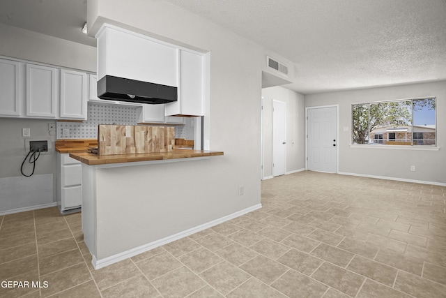 9606 Bahamas St, El Paso, TX 79927 - kitchen with range hood, white cabinets, a textured ceiling, decorative backsplash, and wood counters