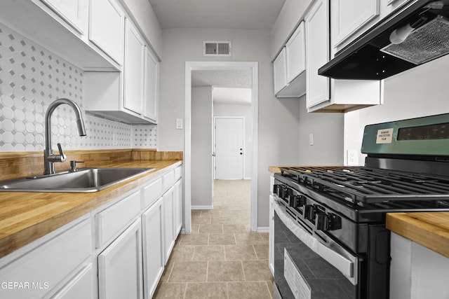 9606 Bahamas St, El Paso, TX 79927 - kitchen with stainless steel range with gas stovetop, ventilation hood, butcher block countertops, and white cabinetry