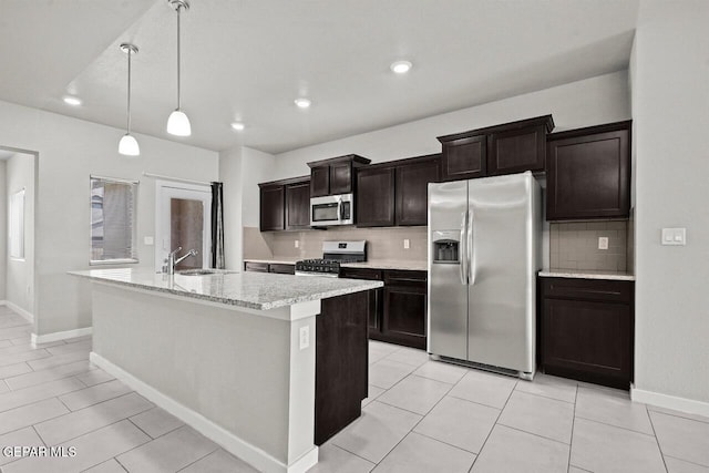 2816 Mike Price Dr, El Paso, TX 79938 - kitchen with appliances with stainless steel finishes, tasteful backsplash, a kitchen island with sink, dark brown cabinetry, and recessed lighting
