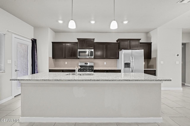 2816 Mike Price Dr, El Paso, TX 79938 - kitchen with refrigerator with ice dispenser, stainless steel microwave, range, a kitchen island with sink, and tasteful backsplash