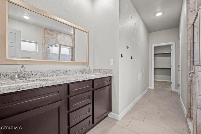 2816 Mike Price Dr, El Paso, TX 79938 - full bath with a stall shower, double vanity, a spacious closet, and tile patterned floors