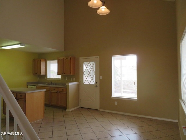 1679 Roger Bombach Dr, El Paso, TX 79936 - kitchen with a sink, light countertops, light tile patterned floors, baseboards, and a towering ceiling