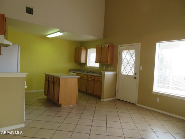1679 Roger Bombach Dr, El Paso, TX 79936 - kitchen featuring freestanding refrigerator, light tile patterned floors, baseboards, light countertops, and a kitchen island