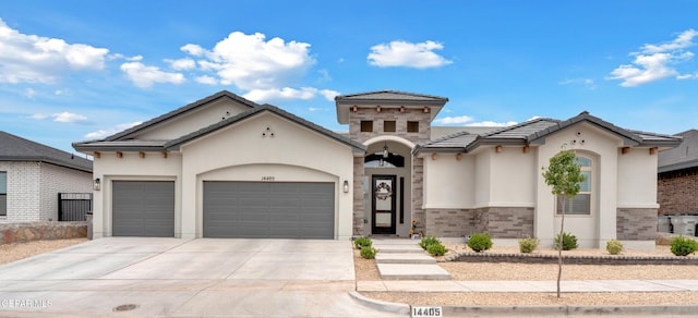14405 Tierra Campeon, El Paso, TX 79938 - view of front of property featuring a garage, concrete driveway, stucco siding, a tiled roof, and brick siding