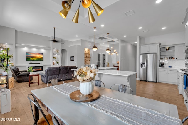 14405 Tierra Campeon, El Paso, TX 79938 - dining room featuring light wood-style floors, arched walkways, recessed lighting, a ceiling fan, and a chandelier