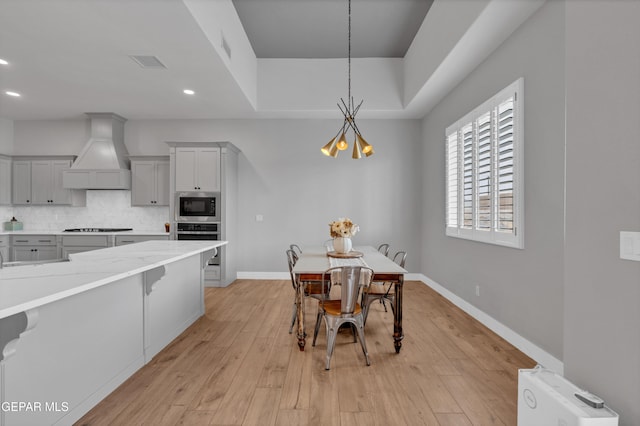 14405 Tierra Campeon, El Paso, TX 79938 - dining space with a chandelier, recessed lighting, light wood-style flooring, baseboards, and a tray ceiling