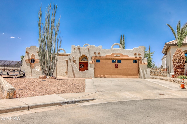 1809 Garden Gate Way, El Paso, TX 79936 - pueblo-style house featuring stucco siding, a garage, and driveway