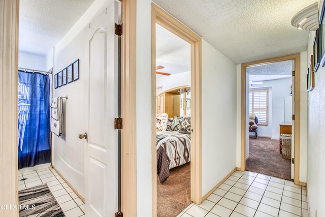 1809 Garden Gate Way, El Paso, TX 79936 - hallway featuring a textured ceiling, light tile patterned flooring, and light carpet