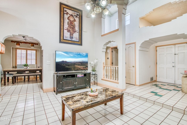 1809 Garden Gate Way, El Paso, TX 79936 - living room featuring arched walkways, a ceiling fan, light tile patterned flooring, and a high ceiling