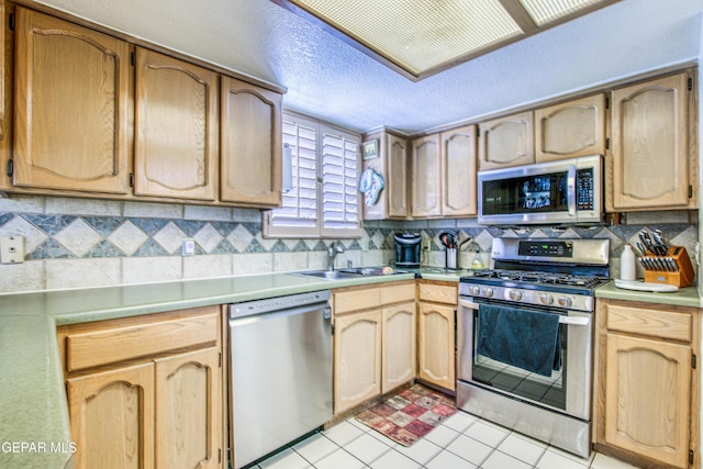 1809 Garden Gate Way, El Paso, TX 79936 - kitchen featuring appliances with stainless steel finishes, backsplash, light countertops, a textured ceiling, and light brown cabinets