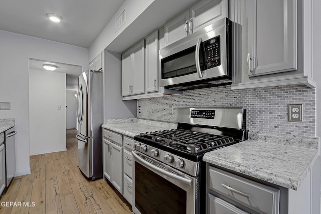 10749 Rushing Rd, El Paso, TX 79924 - kitchen with appliances with stainless steel finishes, light wood-style flooring, tasteful backsplash, and gray cabinets