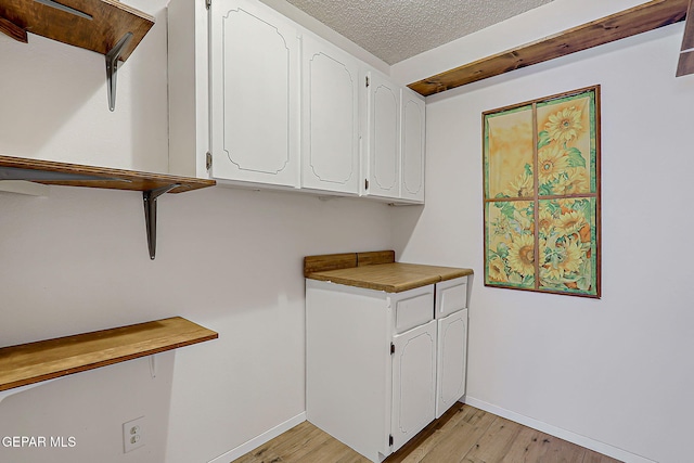 10749 Rushing Rd, El Paso, TX 79924 - washroom with light wood-style floors, baseboards, and a textured ceiling