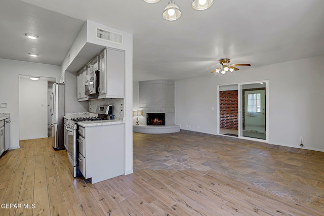 10749 Rushing Rd, El Paso, TX 79924 - kitchen with stainless steel appliances, open floor plan, light wood finished floors, and ceiling fan