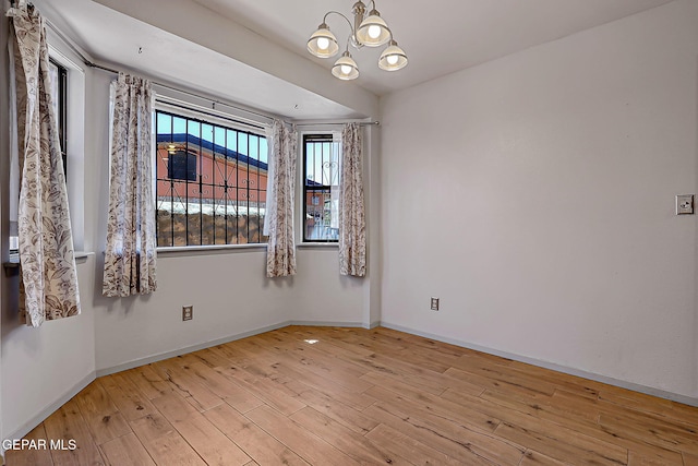 10749 Rushing Rd, El Paso, TX 79924 - unfurnished room featuring a chandelier, hardwood / wood-style flooring, and baseboards