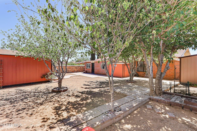 10749 Rushing Rd, El Paso, TX 79924 - fenced backyard featuring an outbuilding and a patio