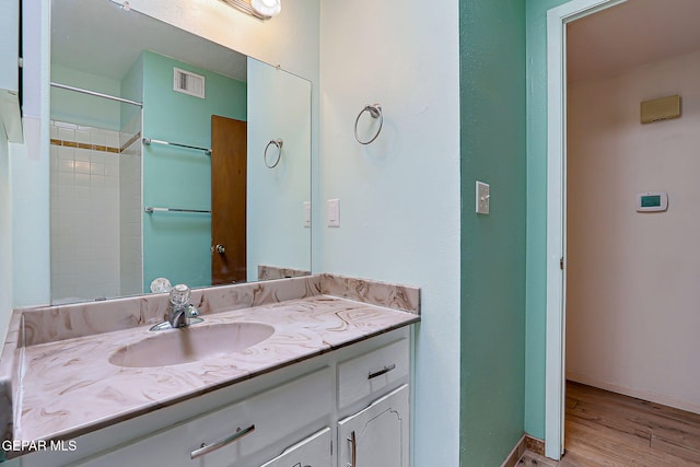 10749 Rushing Rd, El Paso, TX 79924 - full bath with vanity, wood finished floors, baseboards, and a shower