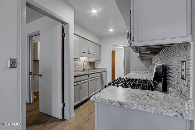 10749 Rushing Rd, El Paso, TX 79924 - kitchen with range with gas cooktop, a sink, backsplash, light wood finished floors, and dishwasher