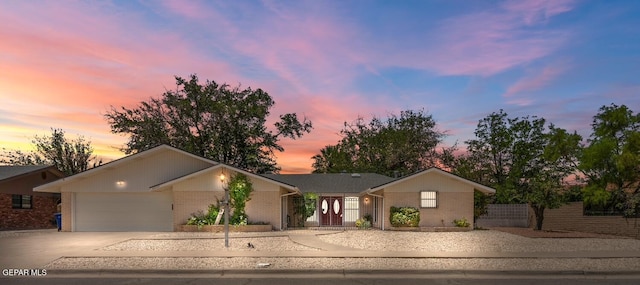 8820 Dirk Ct, El Paso, TX 79925 - ranch-style home with concrete driveway, brick siding, a fenced front yard, and an attached garage