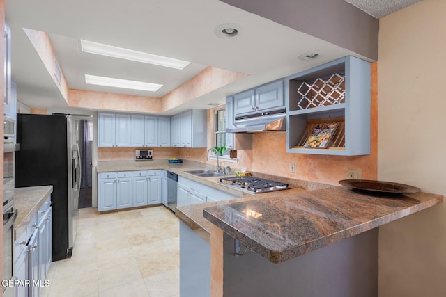 8820 Dirk Ct, El Paso, TX 79925 - kitchen with appliances with stainless steel finishes, under cabinet range hood, a peninsula, dark stone countertops, and a raised ceiling