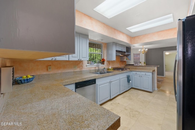 8820 Dirk Ct, El Paso, TX 79925 - kitchen with appliances with stainless steel finishes, a peninsula, a chandelier, under cabinet range hood, and tile countertops