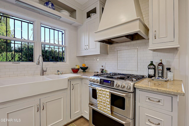 818 Kerbey Ave, El Paso, TX 79902 - kitchen with custom exhaust hood, double oven range, a sink, backsplash, and plenty of natural light