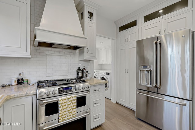 818 Kerbey Ave, El Paso, TX 79902 - kitchen with stainless steel appliances, custom exhaust hood, independent washer and dryer, and white cabinets