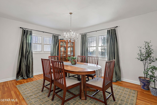 818 Kerbey Ave, El Paso, TX 79902 - dining room featuring a chandelier, light wood-type flooring, plenty of natural light, and baseboards