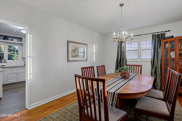 818 Kerbey Ave, El Paso, TX 79902 - dining area featuring a chandelier, light wood-style floors, plenty of natural light, and baseboards