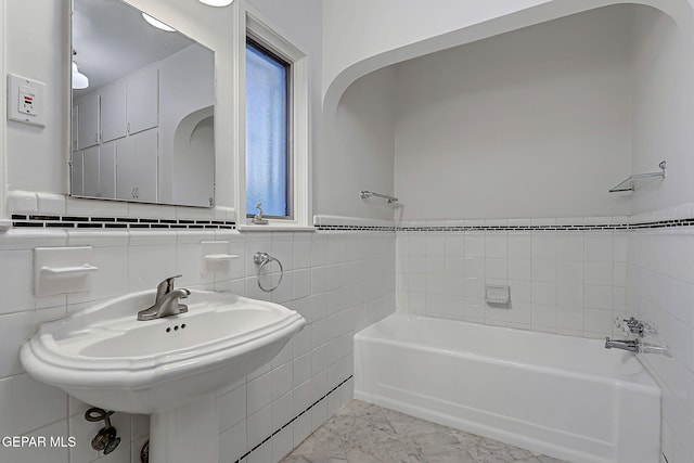 818 Kerbey Ave, El Paso, TX 79902 - bathroom with a bath, tile walls, a sink, wainscoting, and marble finish flooring